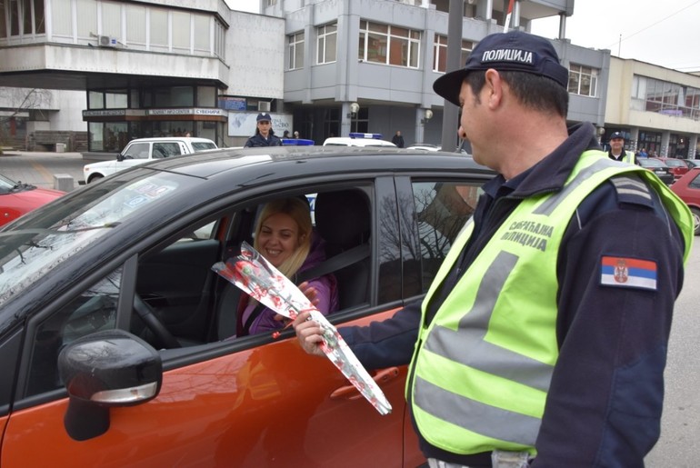 Policajac poklanja karanfil (foto: PU Valjevo)